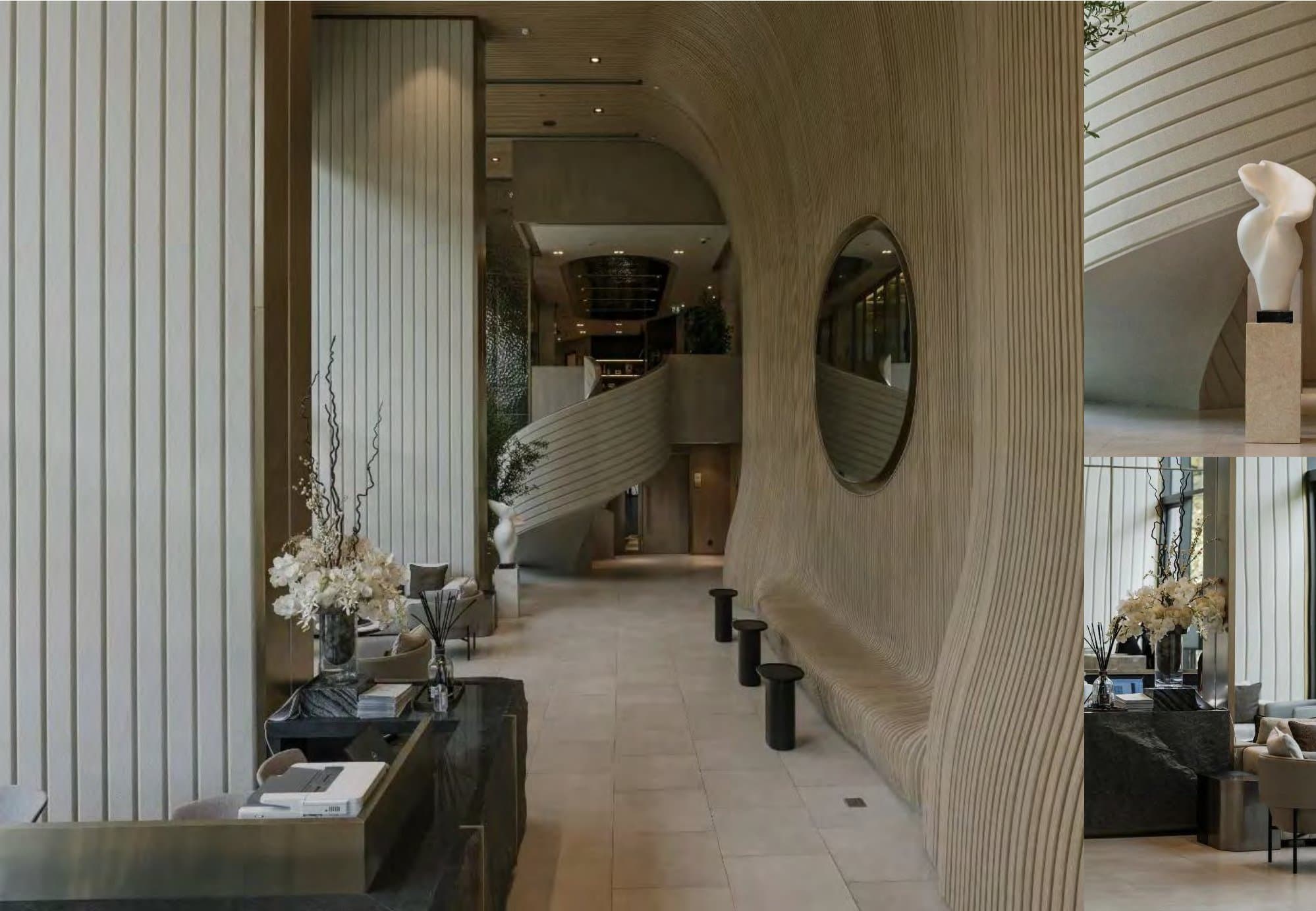 Sweeping lobby corridor lined with organic ribbed plaster walls, a round mirror, sculptural stone console and pale orchids beside a curving staircase.