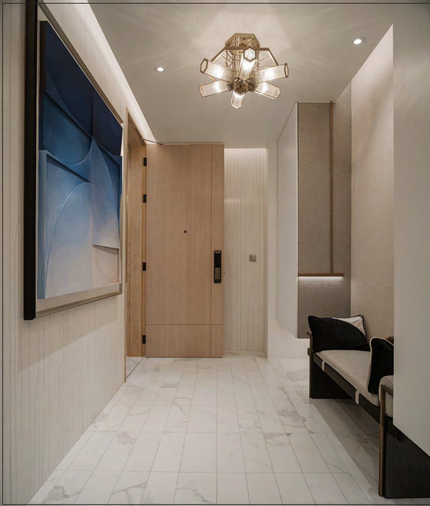 Entry corridor with a large blue relief artwork, brass ceiling light, timber door and pale marble floor to a bench.