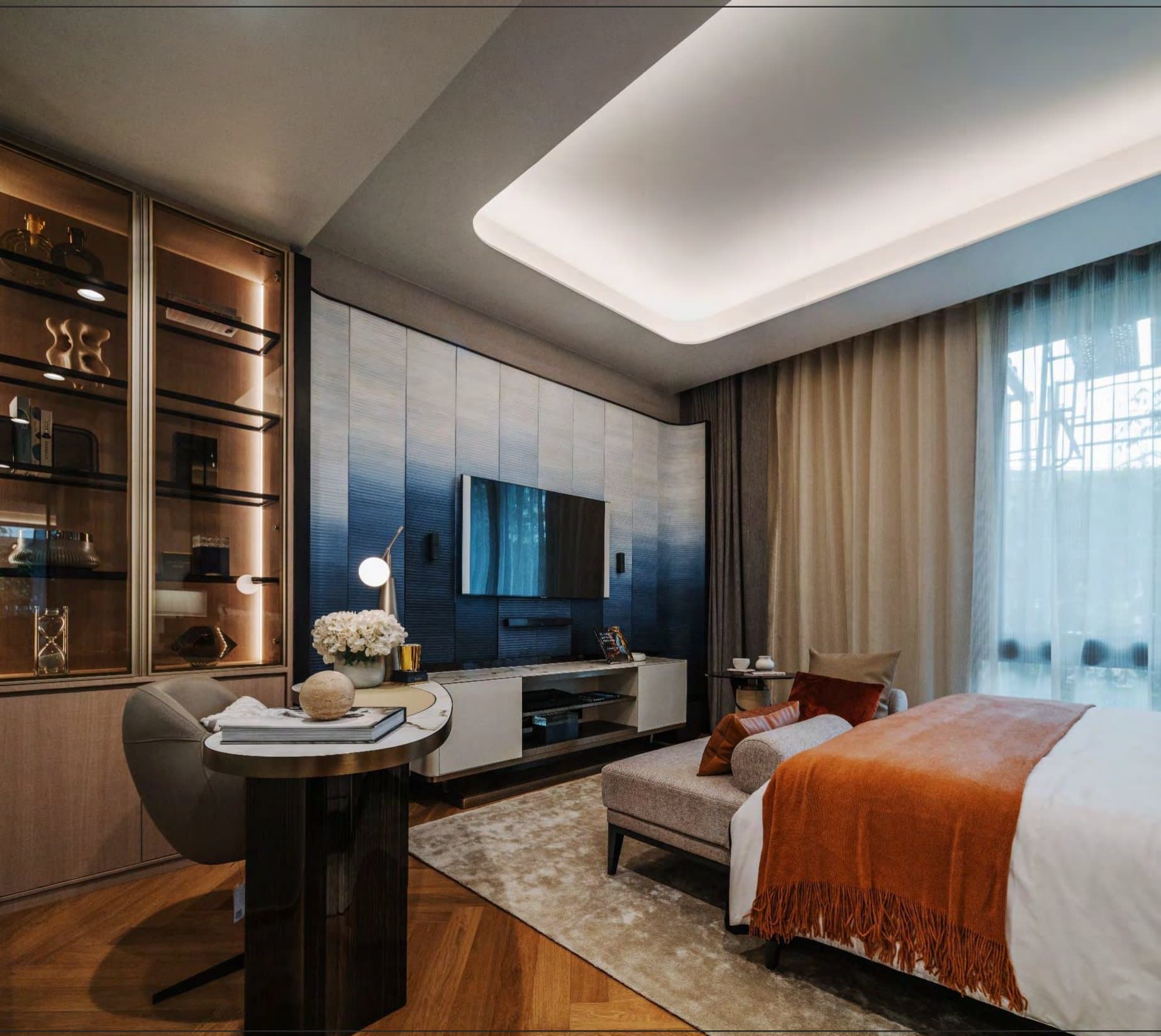 Principal bedroom with an ombré-blue panelled wall, rust bed throw, glass-front display cabinet and a marble-topped writing table.