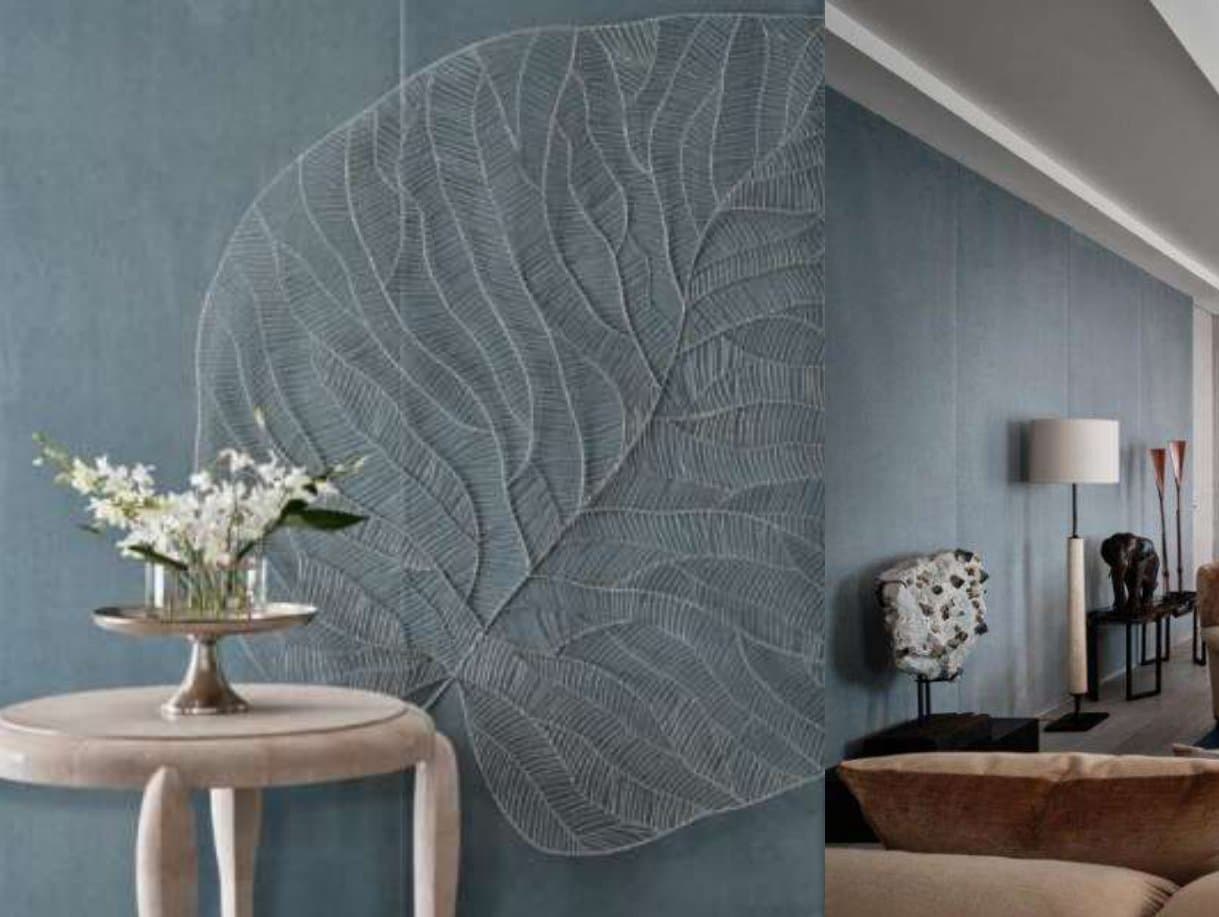 Blue-grey wall carved with an oversized leaf relief beside a round stone table of white orchids, and a lamplit corridor with mineral sculpture.