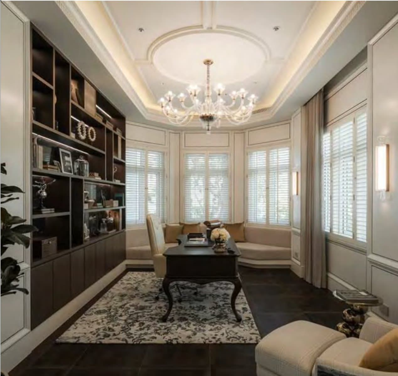 Study lined with a dark timber bookcase, a bay-window seat in plantation shutters and a cabriole-leg desk under a domed cornice