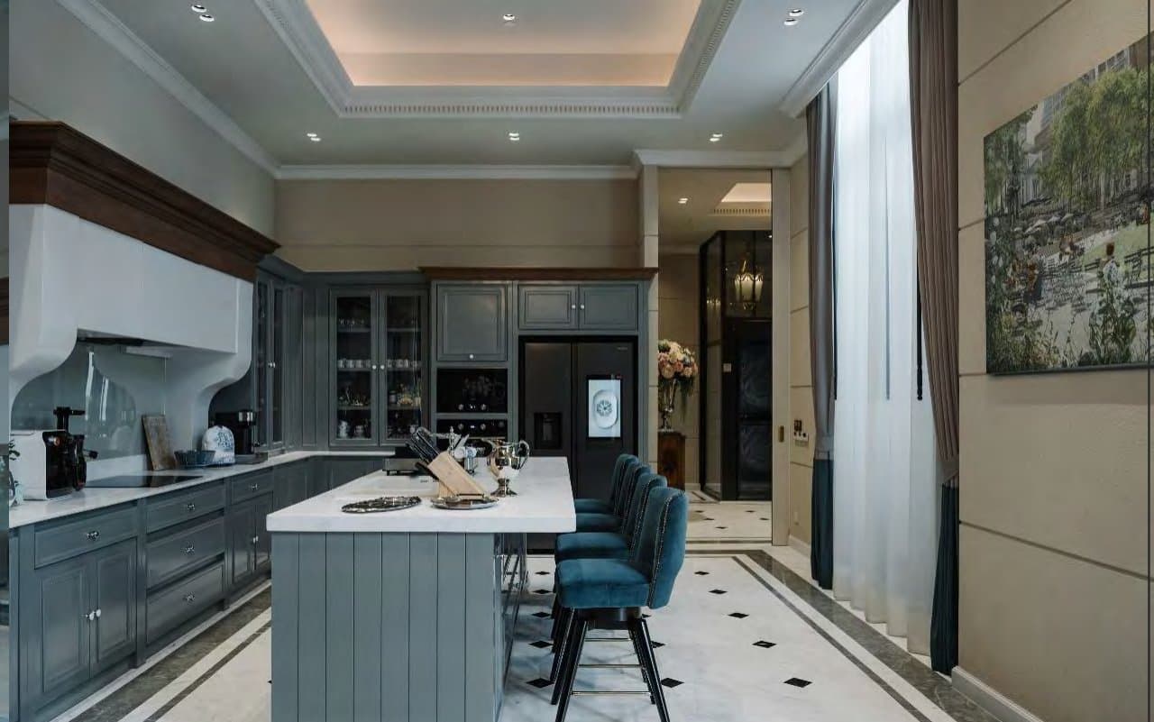 Open kitchen in dove-grey cabinetry with a marble-topped island, teal buttoned bar stools and diamond-inlaid marble floor beneath coffered lighting